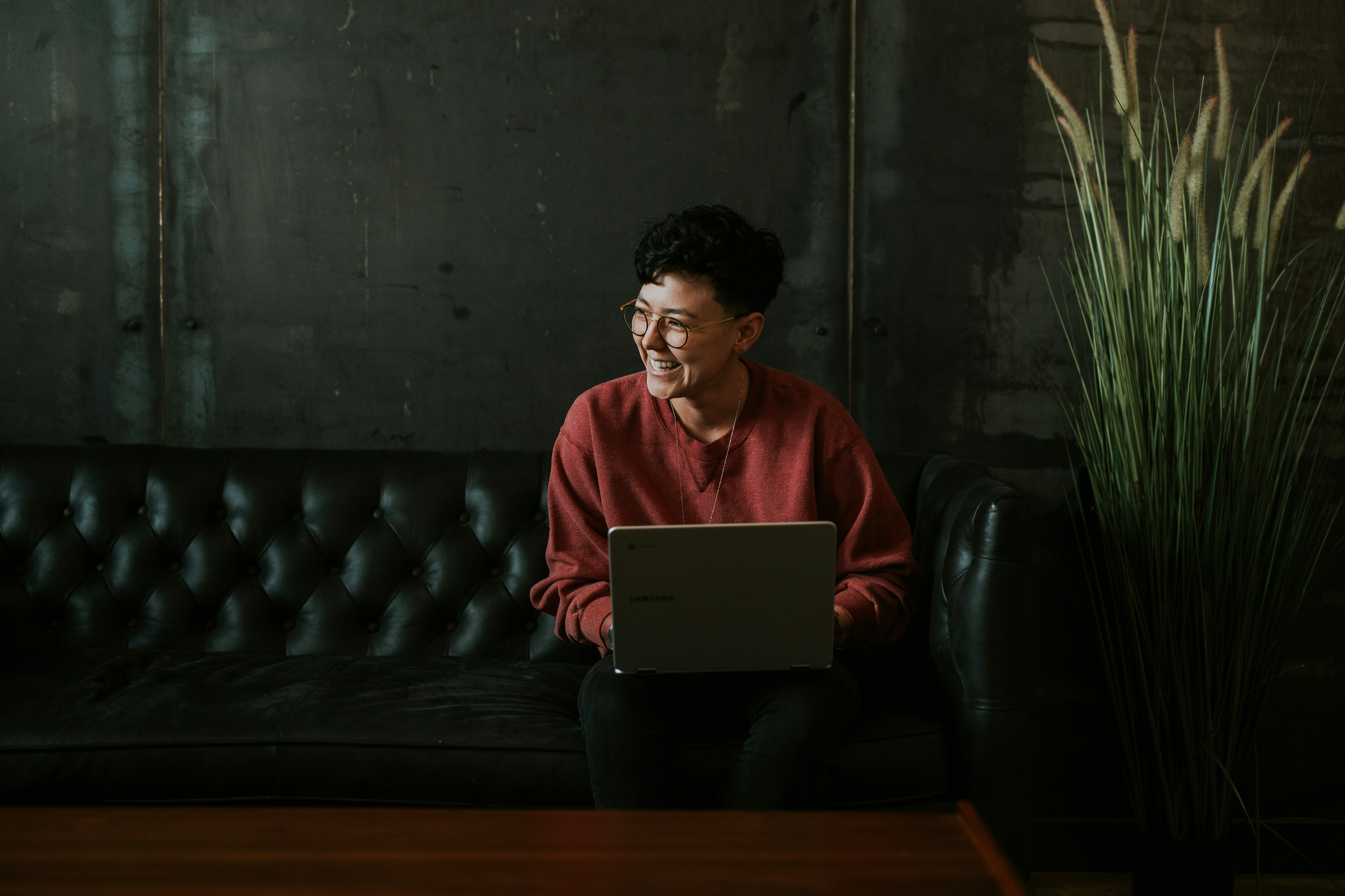 Mature student smiling while studying on a laptop at a kitchen table