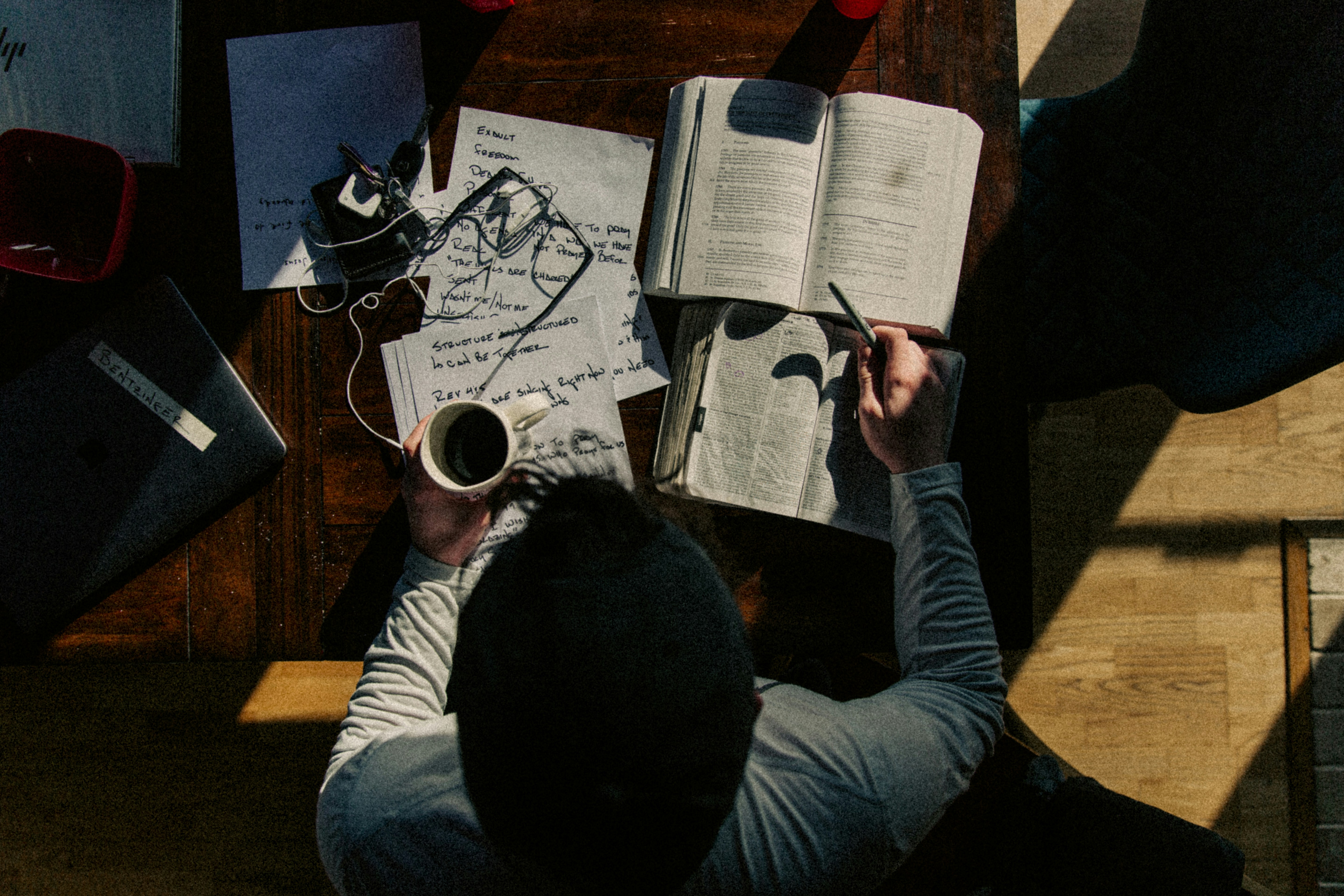 Experienced professional reading research papers at a desk while studying for an online doctorate