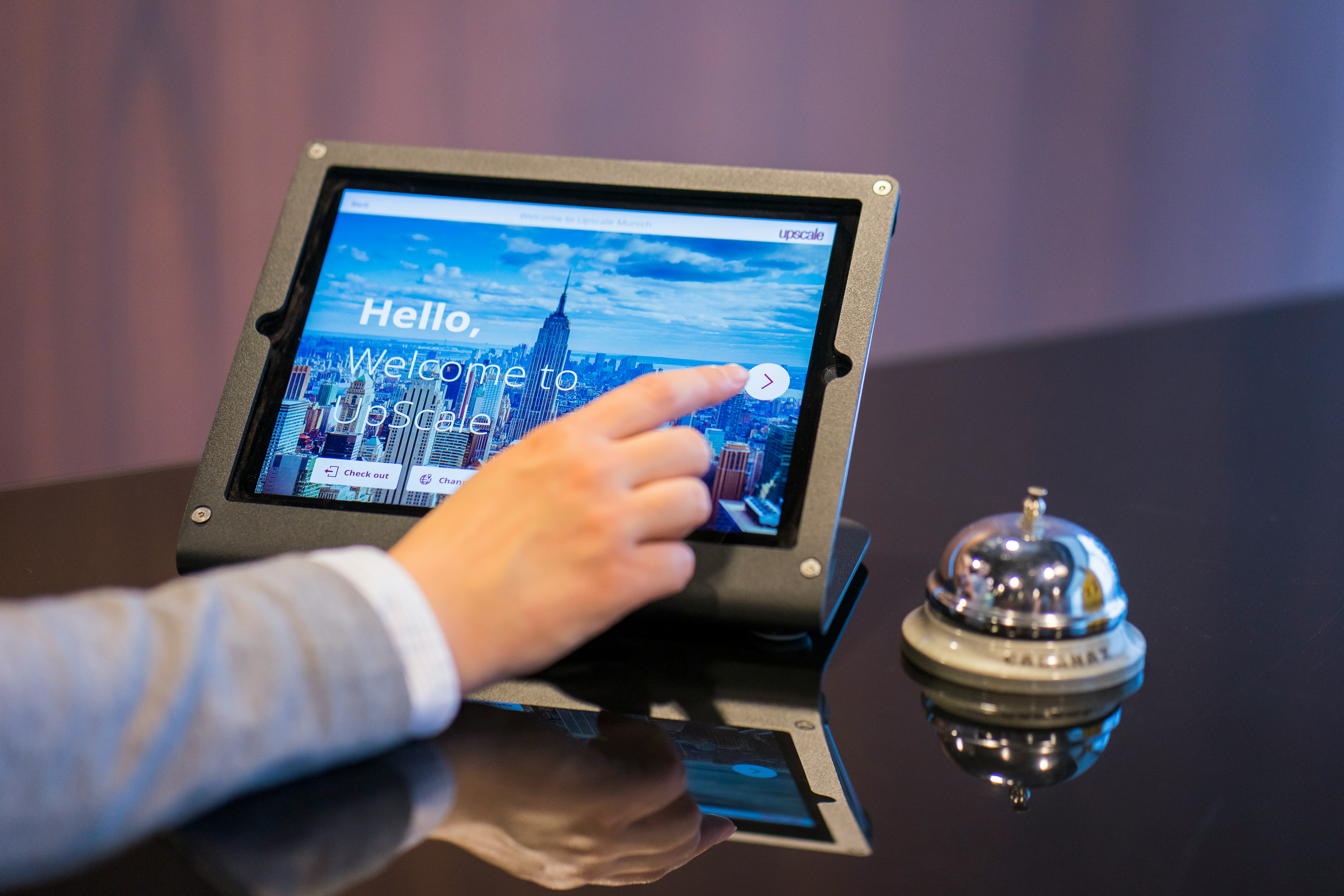 Hospitality professional working on a laptop in a hotel lobby while studying online