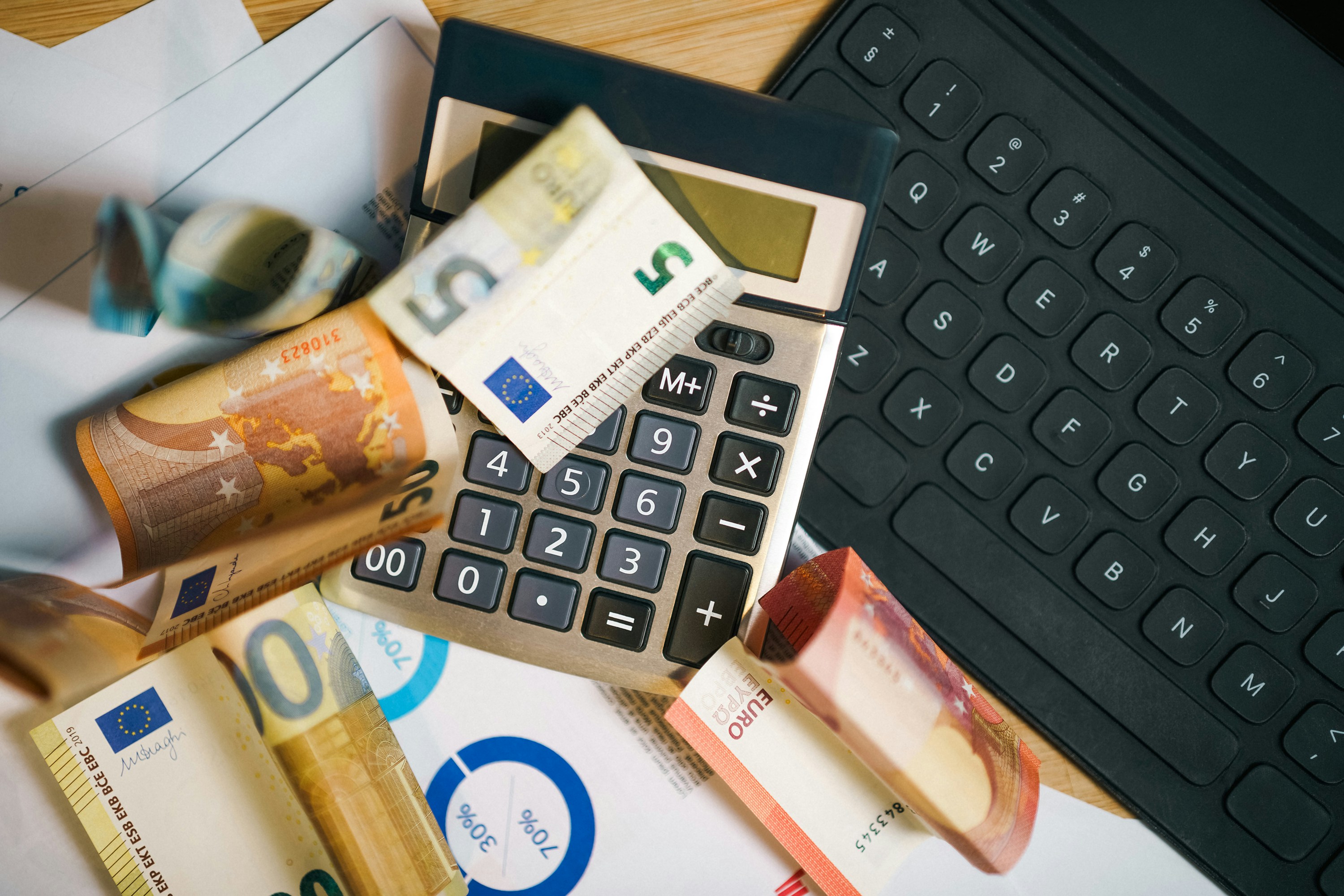 Calculator and laptop on a desk, used for budgeting online degree costs